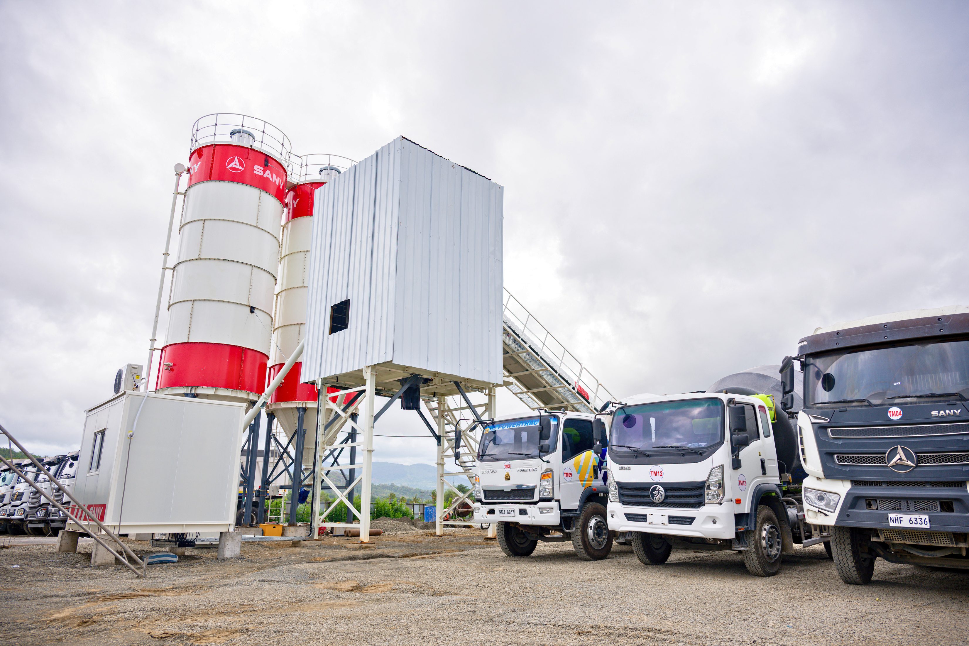 GCDC's SANY batching plant in Occidental Mindoro, with trucks parked beside the silos